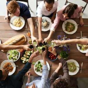 A vibrant group cheers over a delicious meal, showcasing friendship and togetherness.
